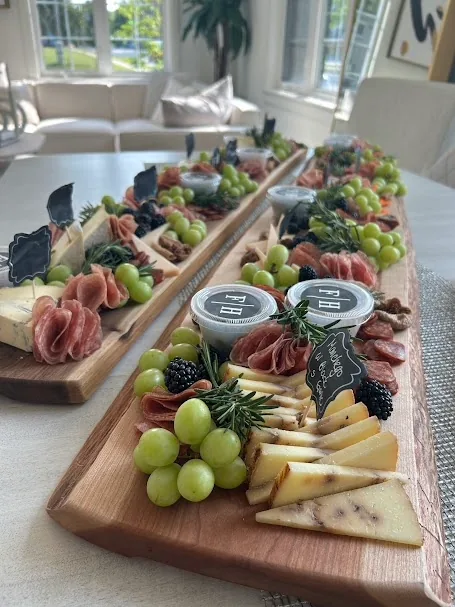 Long custom charcuterie board with cheeses, cured meats and grapes
